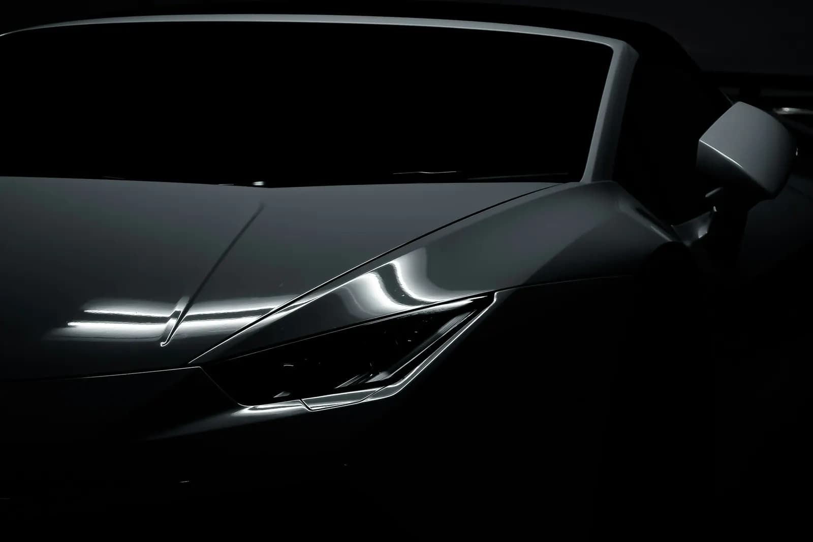 Close-up of a supercar's sculpted bodywork in low light