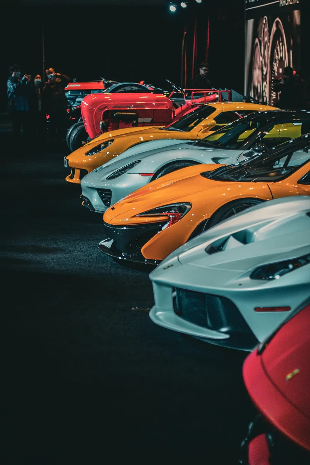 Row of colorful McLaren supercars lined up at night