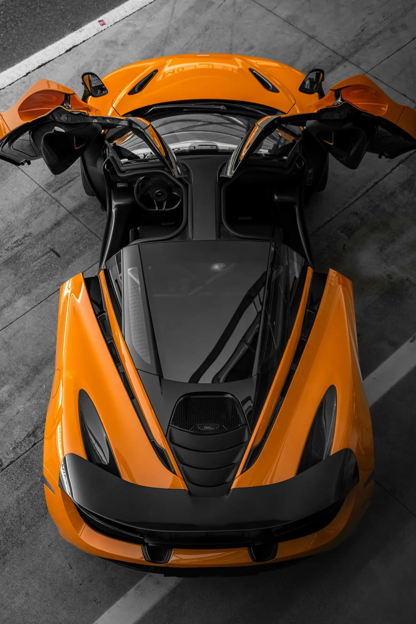 Orange McLaren 720S with dihedral doors open, seen from above