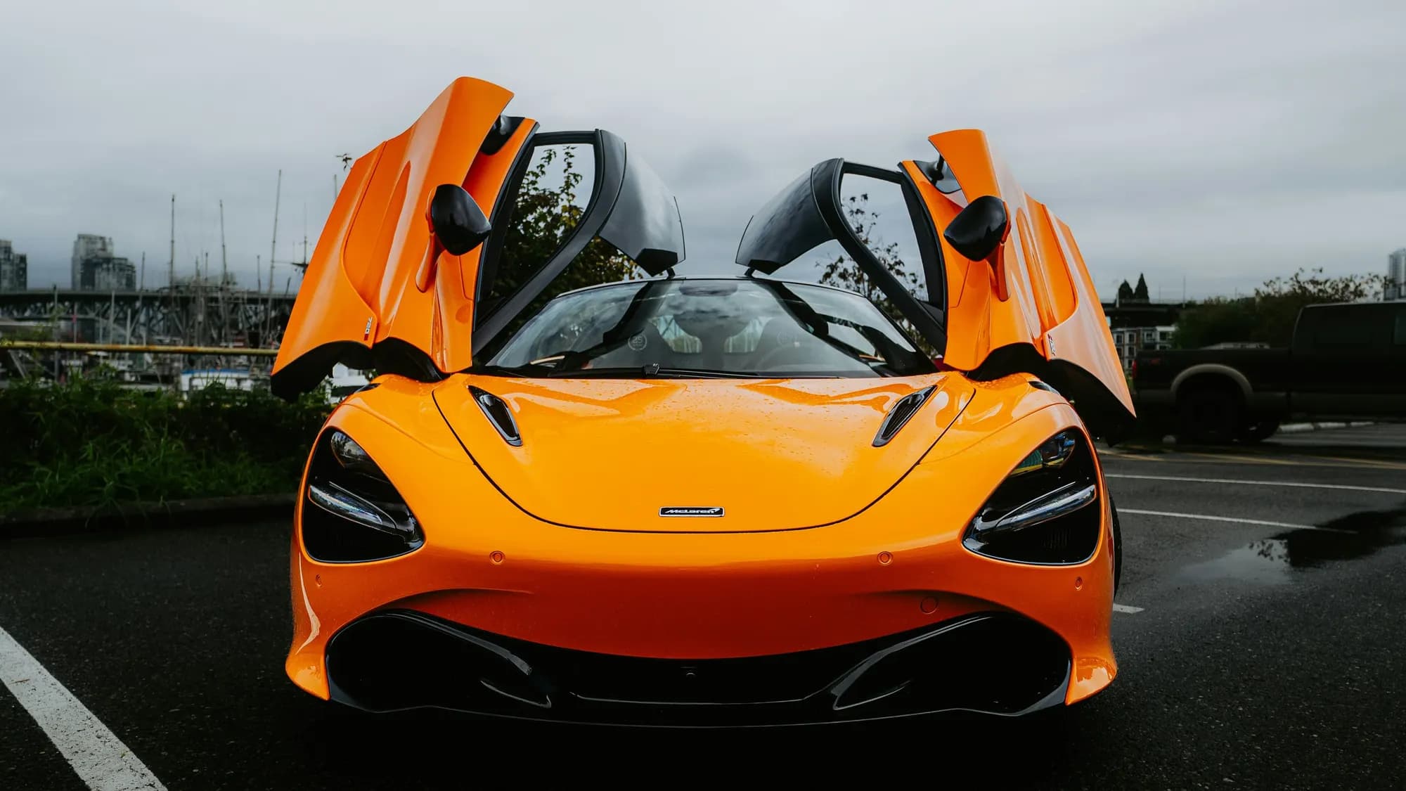 Orange McLaren 720S with dihedral doors open, front view