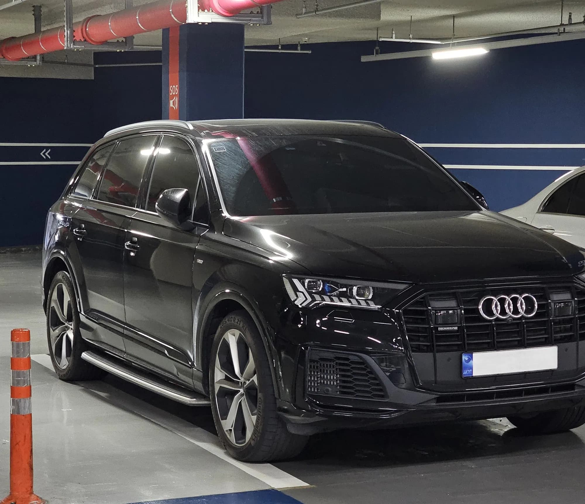 Black Audi Q7 S line, front three-quarter view in a parking garage
