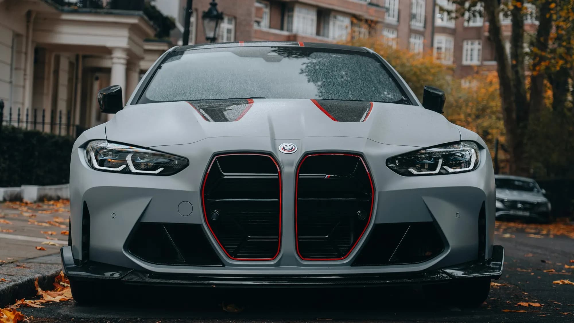 Grey BMW M4 CS on a rainy autumn street, front view
